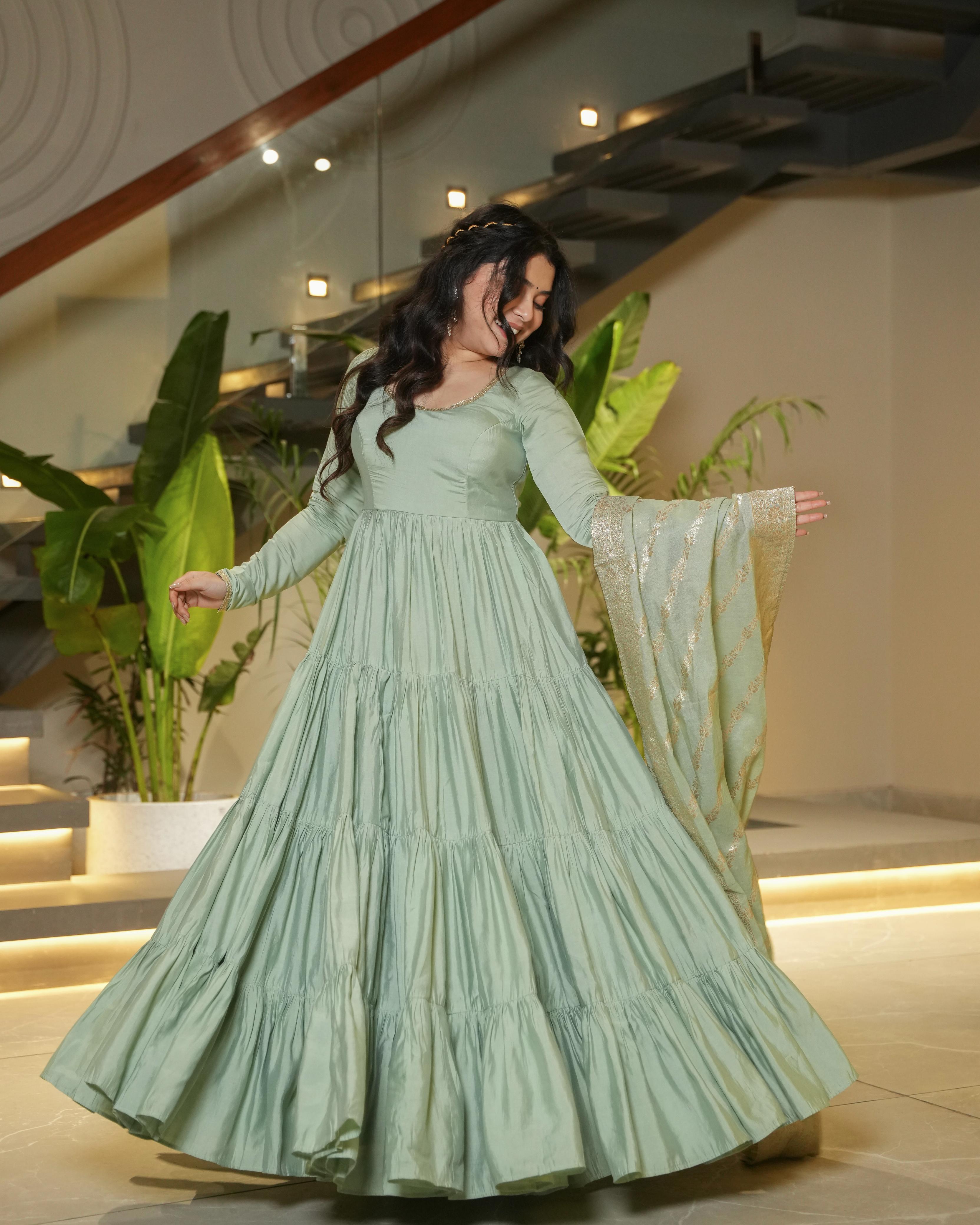 Pista green Roman silk Chanderi Anarkali suit set with Banarasi dupatta, flared Anarkali gown for wedding functions and festive wear, designer frill Anarkali with 9-meter flair, Chanderi silk ethnic suit for women, Banarasi dupatta suit for reception and party wear, pista color Anarkali dress for haldi, mehendi, or Eid, lightweight Anarkali kurta pant set with traditional embroidery.
